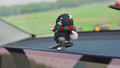 rose colored moving bear decoration on car dashboard
